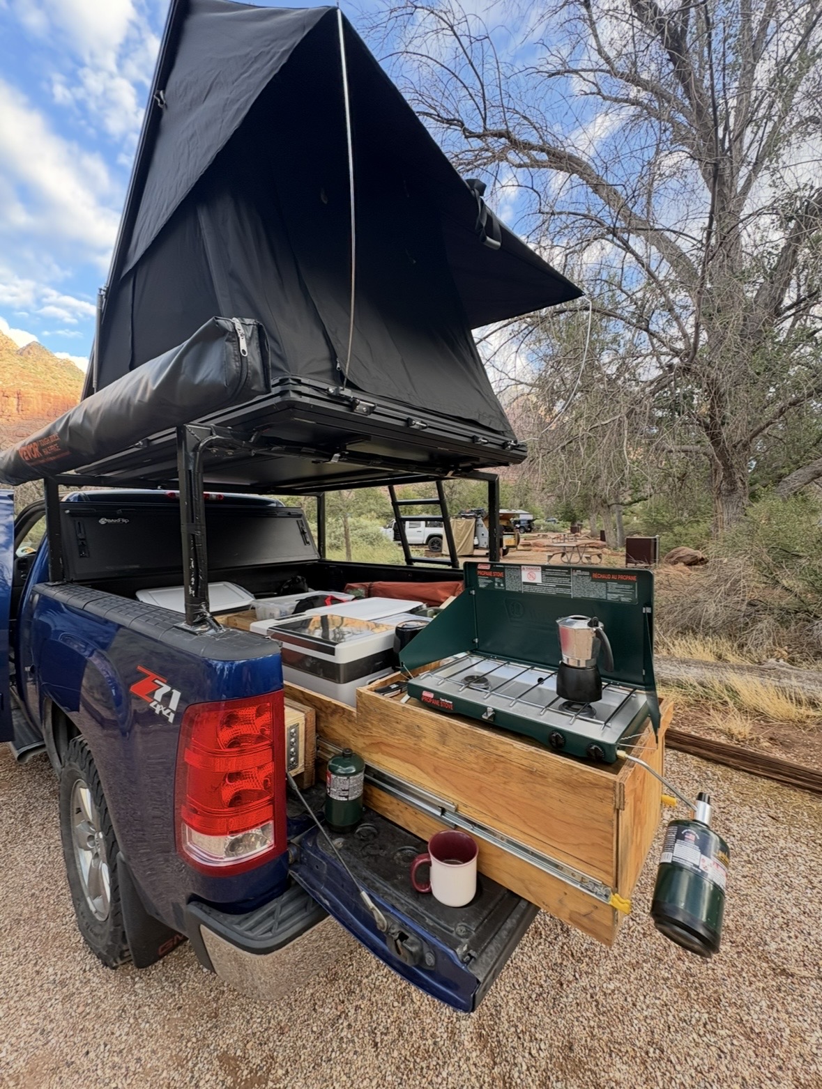 Truckie with the roof top tent open and the camp kitchen slid out of the tailgate